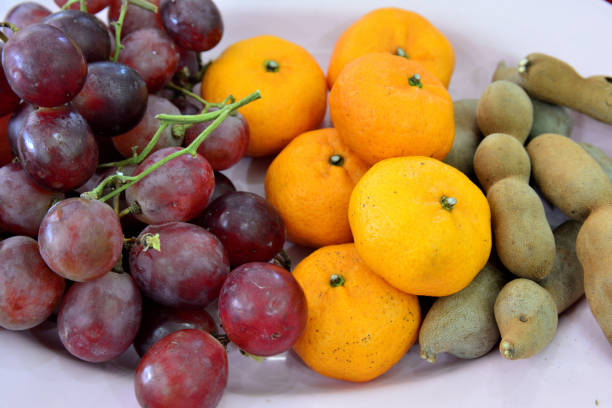 istock orange grapes and tamarindes on dish 640182354