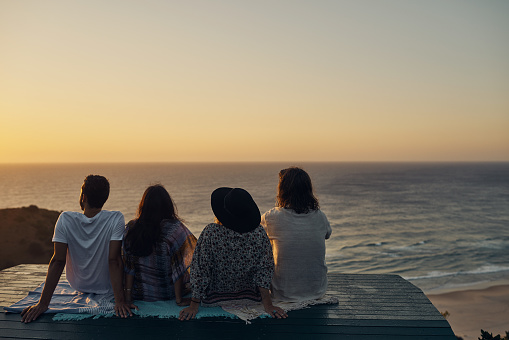 Shot of four friends watching the sunset on a double date
