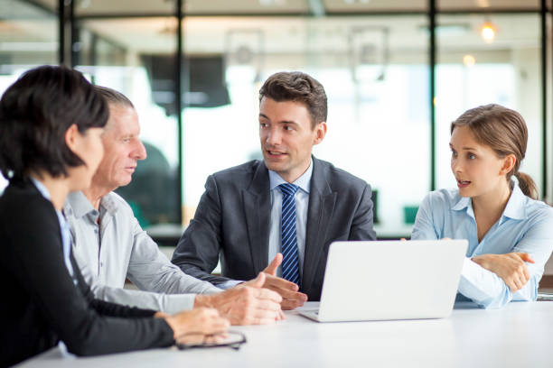 istock Four Business People Discussing Project at Desk 640183470