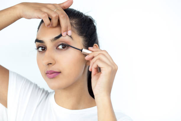 istock Pretty Indian Lady Applying Mascara on Eyelashes 640183486