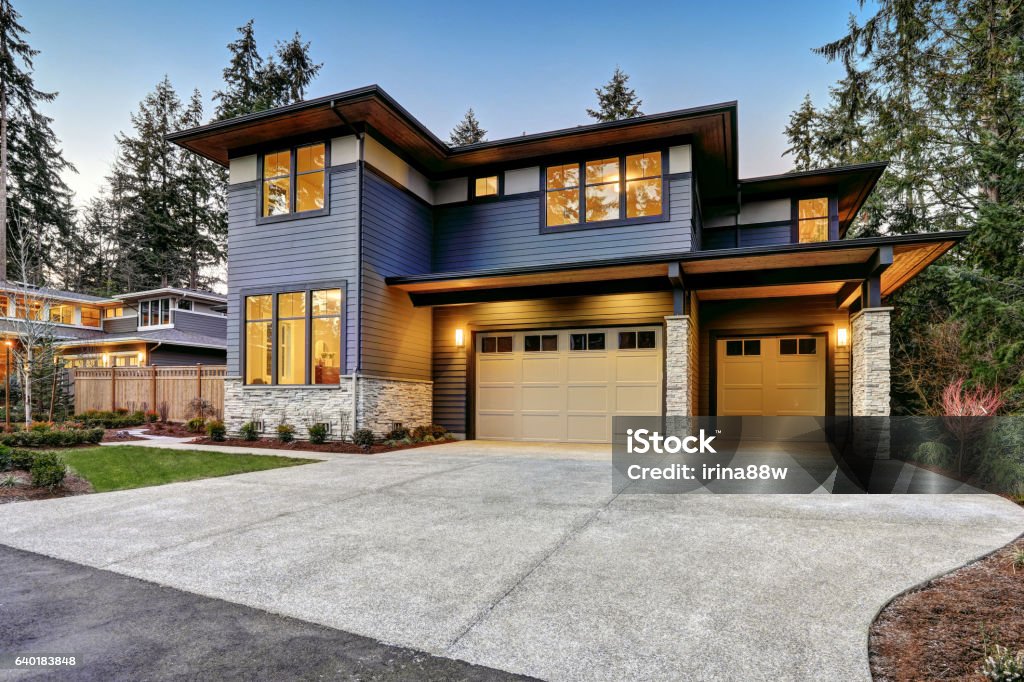 Luxurious new construction home in Bellevue, WA Luxurious new construction home in Bellevue, WA. Modern style home boasts two car garage framed by blue siding and natural stone wall trim. Northwest, USA Outdoors Stock Photo