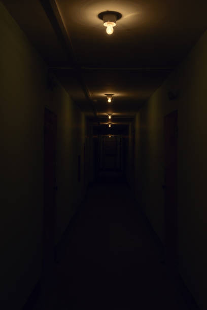 istock dark corridor with glowing lamps on the ceiling 640184778
