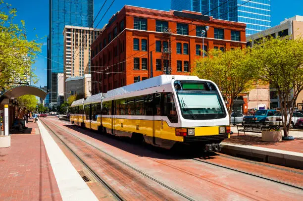 Wide angle view of a DART light rail train at a station in downtown Dallas.