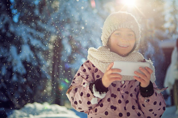 ragazza sta messaggiando sotto la neve che cade - cold discussion outdoors snow foto e immagini stock