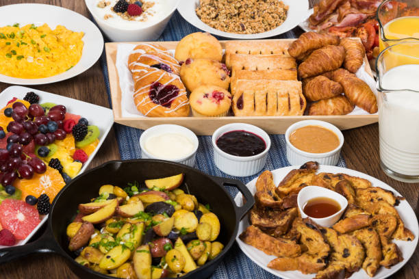 Premium Breakfast Buffet Overview of a breakfast buffet with muesli, yoghurt, fruit, baked goods,hash browns, scrambled eggs, preserves, bacon and sausage, orange juice and milk french toast bacon bread butter stock pictures, royalty-free photos & images