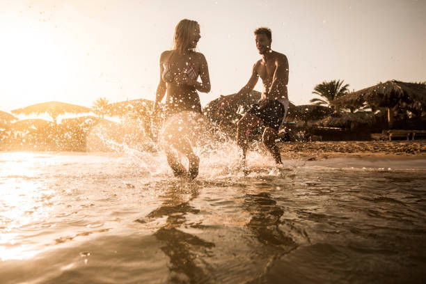 istock Playful couple having fun while chasing in the sea. 640190206