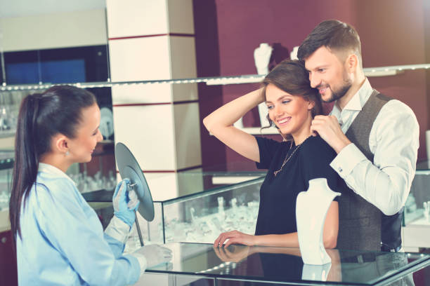 istock Couple looking at mirror when man trying necklace. 640192470