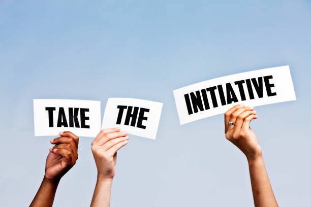 Hand-held signs say " Take the initiative" against sky blue Three hands hold up signs reading "Take the initiative" against a sky-blue background with copy space. initiative stock pictures, royalty-free photos & images