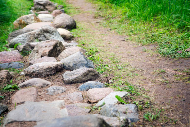 istock Path from cobble-stones on green herbs a background 640199640