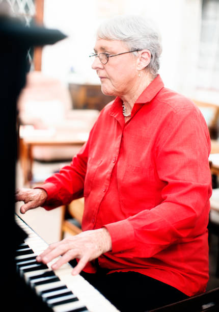 istock White-haired senior woman plays the piano 640200098
