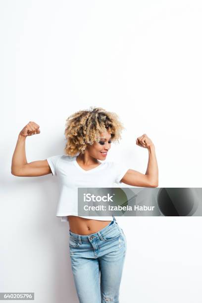 Afro American Young Woman Flexing Arms Stock Photo - Download Image Now - Flexing Muscles, One Woman Only, Women