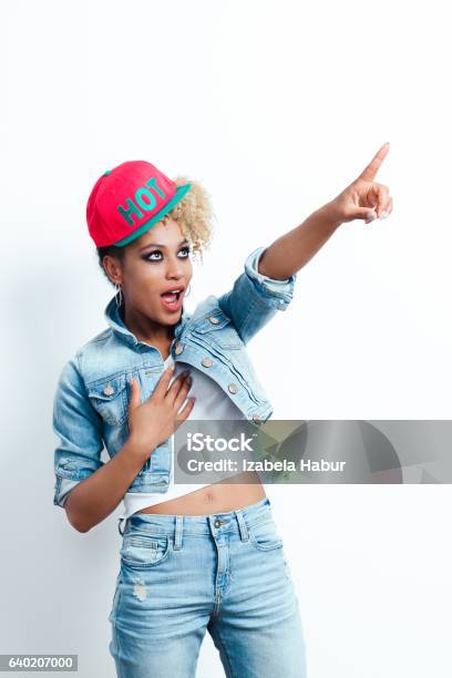 Excited Afro American Young Woman Pointing Stock Photo - Download Image Now - Cool Attitude, Pointing, Studio Shot