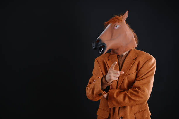 hombre con chaqueta naranja con una máscara de caballo - business men humor macho fotografías e imágenes de stock