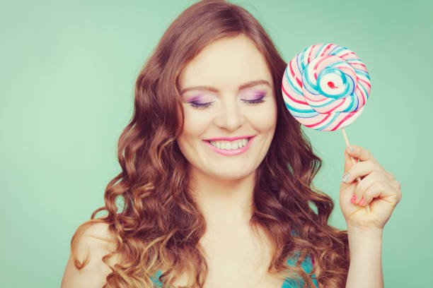 istock Smiling girl with lollipop candy on teal 640208132