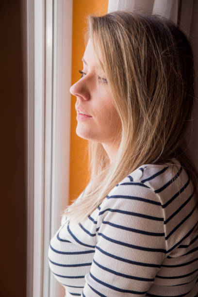 istock Sad woman looking through the window 640208188
