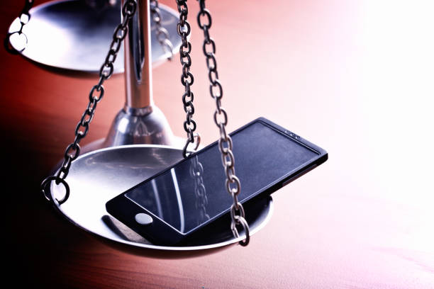 символические весы правосудия держать мобильный телефон - tip off стоковые фото и изображения