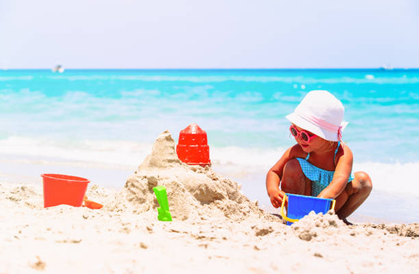 istock cute little girl play with sand on beach 640212634