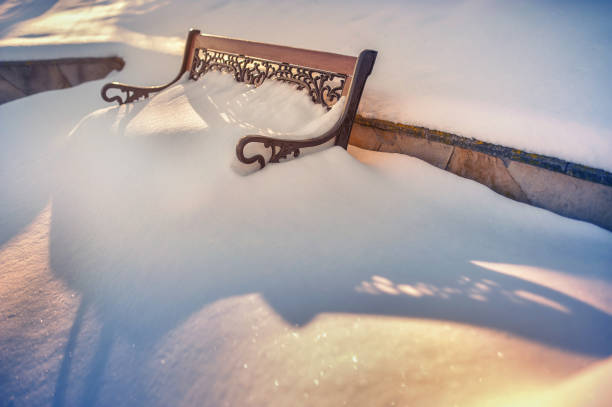 bench in the snow at sunrise