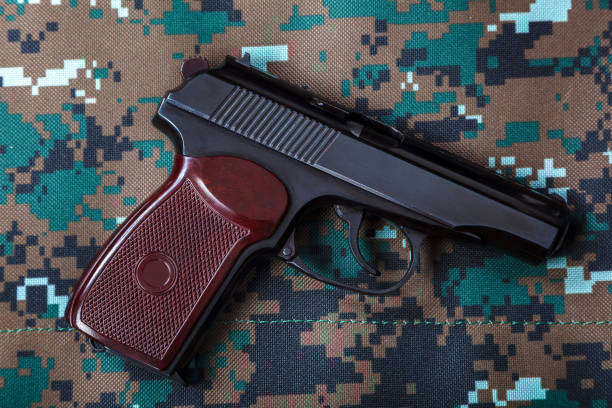 istock Gun on camouflage background. Weapons. Tactical gun. 640214672