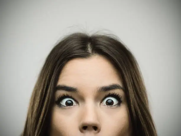 Photo of Surprised woman smiling against gray background