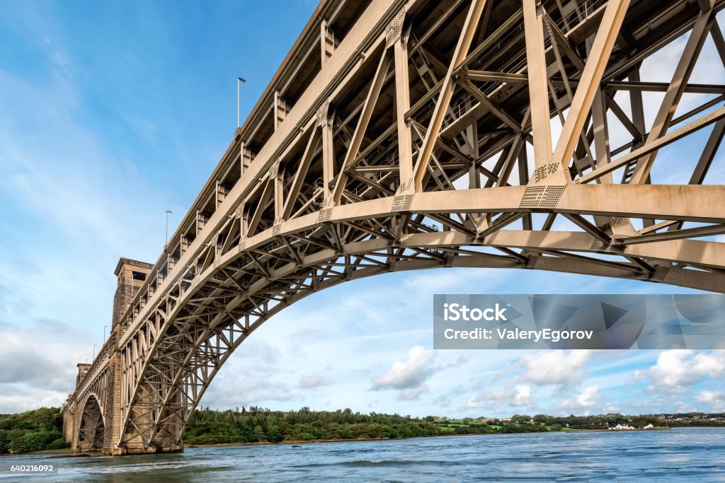 Britannia bridge over Menai Strait in North Wales View of Britannia bridge across Menai Strait between island of Anglesey and mainland of Wales. Copy space in sky. Bridge - Built Structure Stock Photo