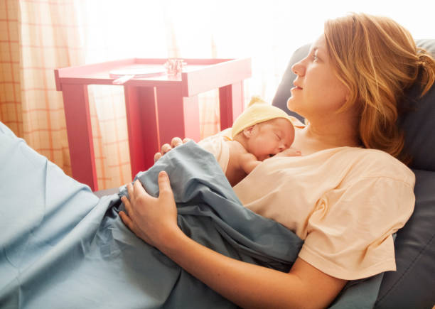 Premature baby girl resting on mother's breasts Premature baby born at 25th week of pregnancy sleeping during the kangaroo care session in hospital. Genuine emotions, real scene. Natural light. premature stock pictures, royalty-free photos & images