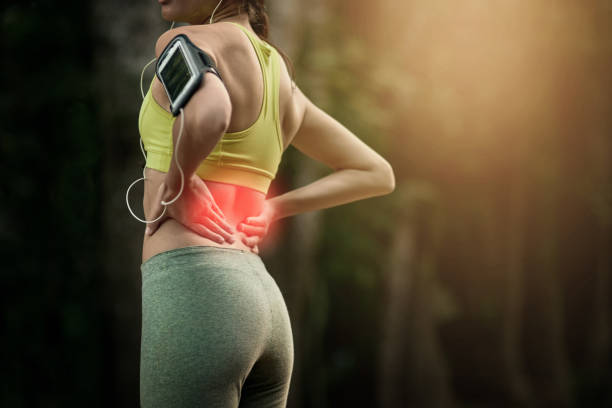 Why suffer when you can just warmup Cropped shot of a young woman experiencing lower back pain lower back pain stock pictures, royalty-free photos & images