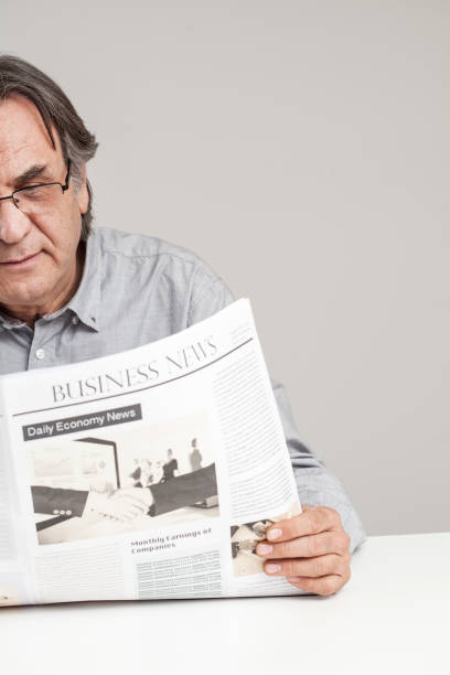 istock Senior man reading newspaper on table 640223250