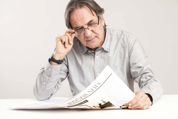 istock Senior man reading newspaper on table 640223512