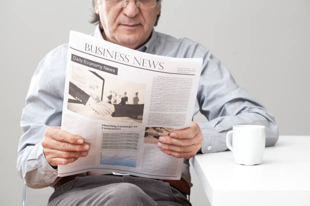istock Senior man reading newspaper on table 640225262