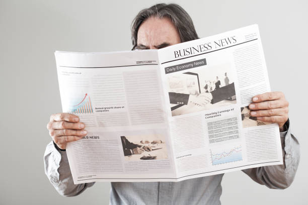 istock Senior man reading newspaper on gray background 640225616