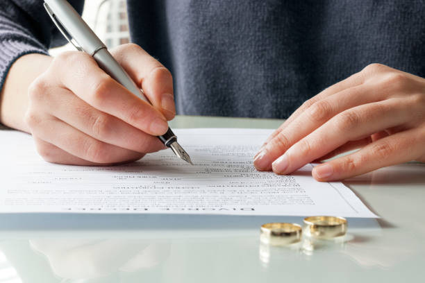 istock Wife signs divorce decree form with ring 640226358