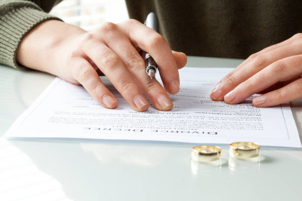 istock Wife signs divorce decree form with ring 640226652
