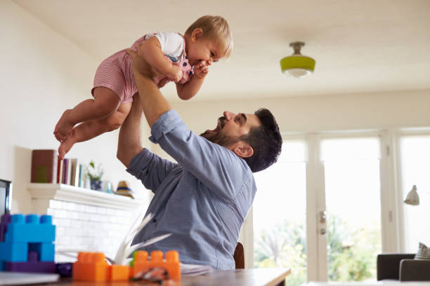 istock Father Sits At Table And Plays With Baby Son At Home 640227214