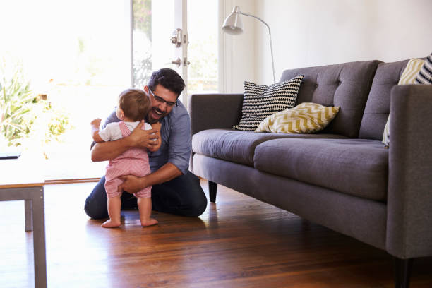 istock Father Watching Baby Daughter Take First Steps At Home 640228580
