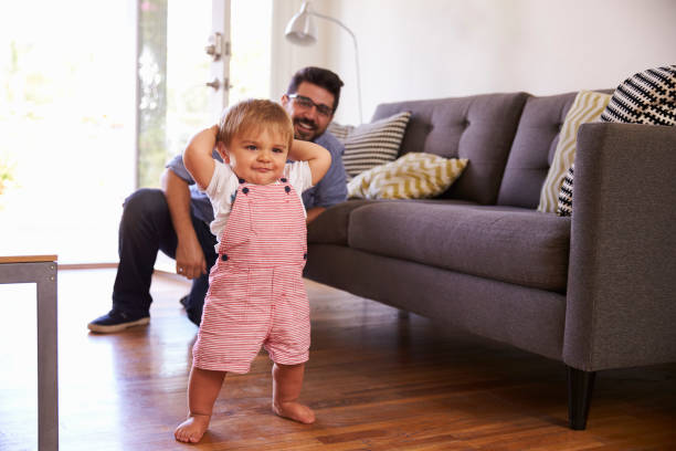 istock Father Watching Baby Daughter Take First Steps At Home 640228654