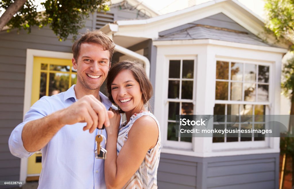Paar mit Schlüsseln stehen vor neuem Zuhause - Lizenzfrei Eigenheim Stock-Foto