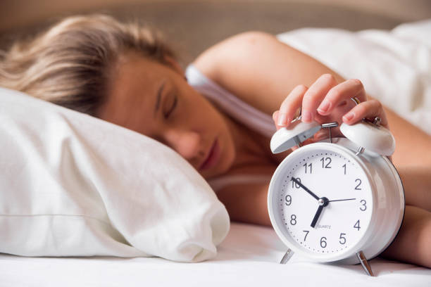 istock Alarm clock and sleeping young woman 640228752