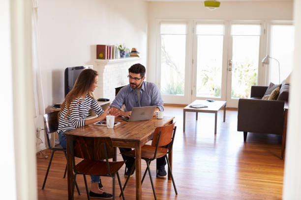 istock Couple Sitting At Table Using Laptop Together 640228878