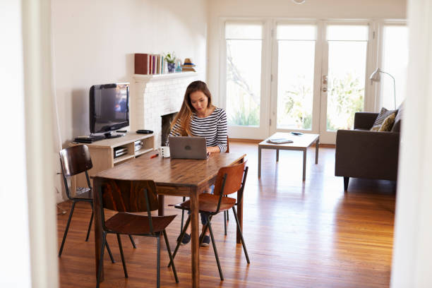 istock Woman Working From Home Using Laptop On Dining Table 640228884