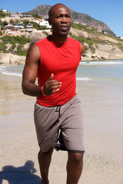 istock Exercising african american man jogging on the beach 640231458