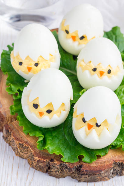 istock Little chicken in nest, deviled eggs on wooden board, vertical 640231478