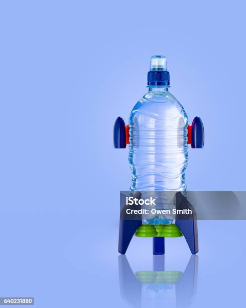 Water Bottle In The Form Of A Rocket On Blue Stock Photo - Download Image Now - Rocketship, Bottle, Water