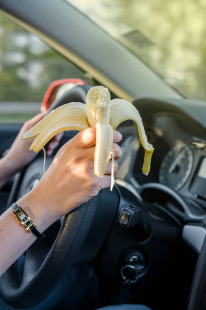 istock Woman eating banana while driving on highway 640232104