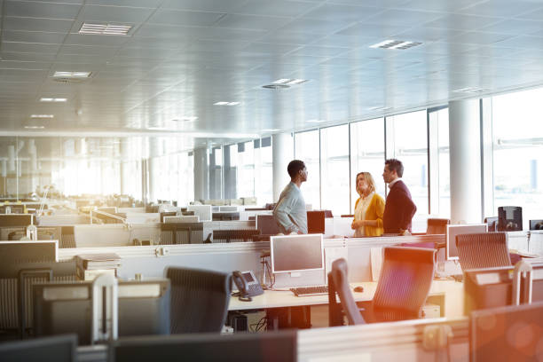 Casual catch up in the office Shot of a group of businesspeople talking together in an office office cubicle photos stock pictures, royalty-free photos & images