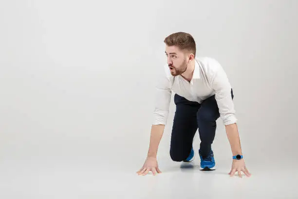 Photo of businessman with beard in white shirt on position of start