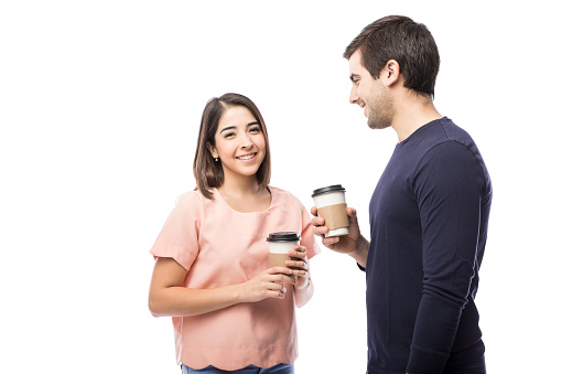 Portrait of a gorgeous young Hispanic woman enjoying a cup of coffee with her boyfriend in a studio