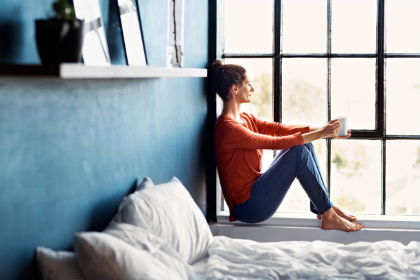 pasar la mañana viendo pasar el mundo - mujer pensativa mirando por la ventana fotografías e imágenes de stock