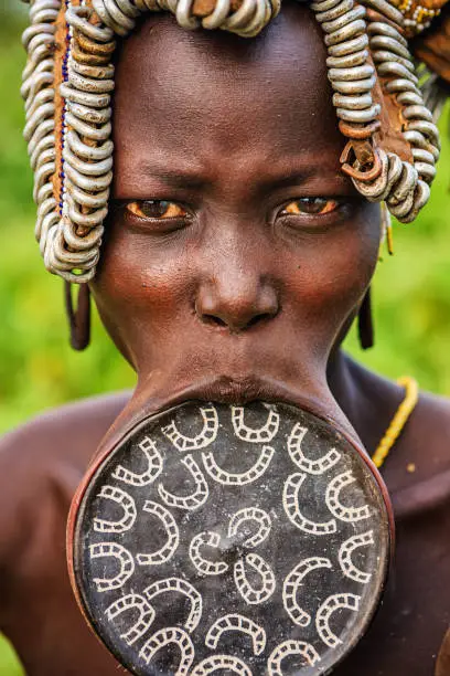 Woman from Mursi tribe with lip plate. Mursi tribe are probably the last groups in Africa amongst whom it is still the norm for women to wear large pottery or wooden discs or ‘plates’ in their lower lips.http://bhphoto.pl/IS/ethiopia_380.jpg