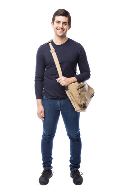 Handsome university student in a studio Full length view of a handsome Hispanic university student in a white background shoulder bag stock pictures, royalty-free photos & images